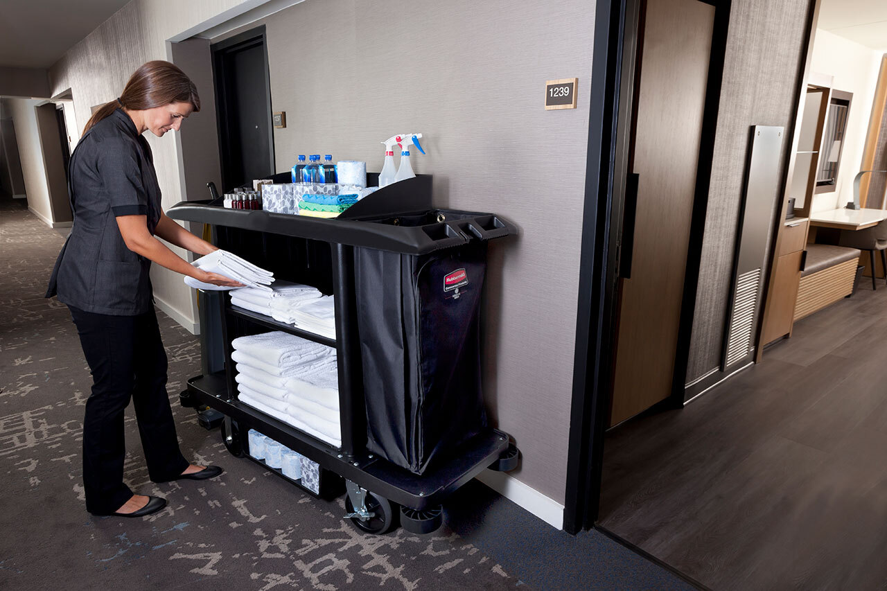A housekeeper organising cleaning equipment on Rubbermaid's Executive Traditional Compact Housekeeping Cart
