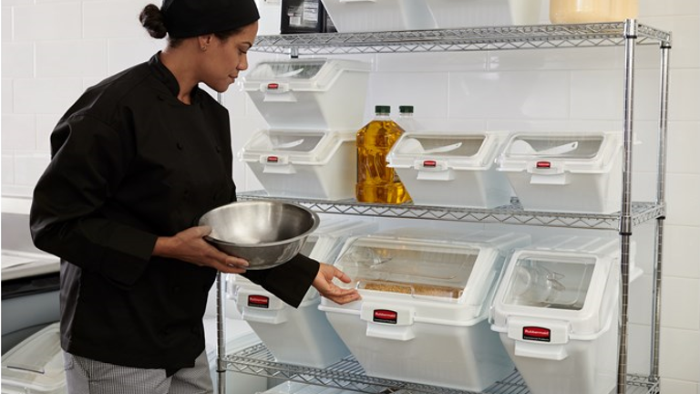 A restaurant staff getting some ingredient from the Rubbermaid Commercial ProSave Shelf Ingredient Bins