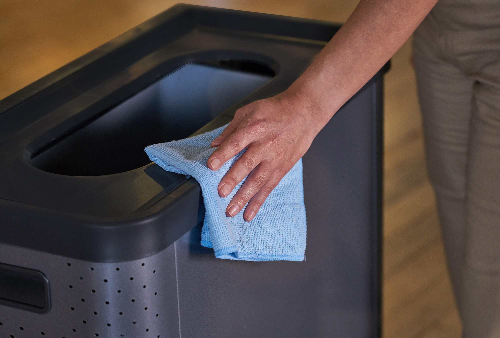 A person cleaning a bin using the Microfibre Light Commercial Cloth